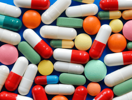 Colourful medication and pills fill the entire photo