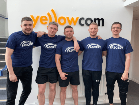 Yellowcom staff smile for the camera wearing ASCERT t-shirts.