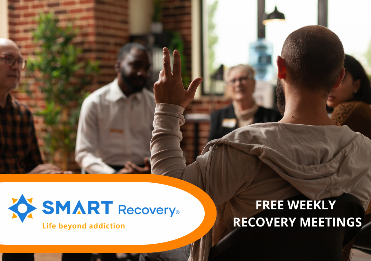 A group of people sit around in a circle for a SMART Recovery meeting.